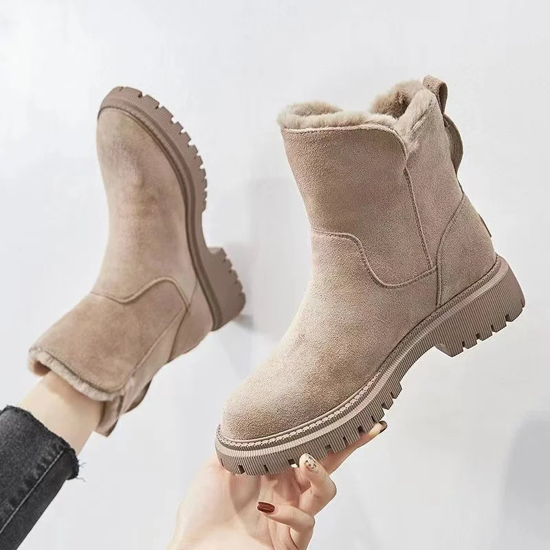 Tessa beige laars vastgehouden in de hand, zijaanzicht met profielzool